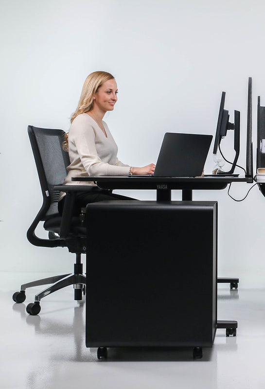 Frau arbeitet in einem Büro mit schwarzen Möbeln um dem Yaasa File Cabinet in schwarz