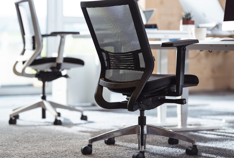 Schwarzer und weißer ergonomischer Bürostuhl in einem Büro
