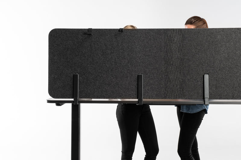 Zwei Personen hinter einer Tischtrennwand auf einem höhenverstellbaren Yaasa Desk montiert