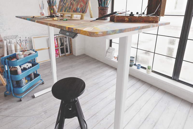 Elektrisch höhenverstellbares Tischgestell mit künstlerischer Tischplatte in einem Atelier 