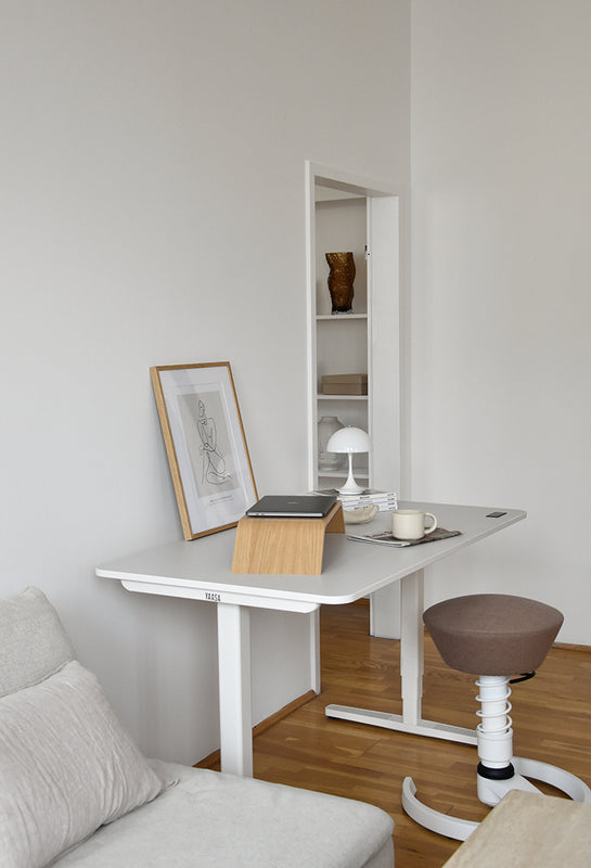 Weißer Yaasa Desk Pro 2 mit einem Sitzhocker in einem Wohnraum